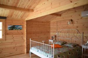 a log cabin bedroom with a bed and wooden walls at Cyprus Glamping Park in Ayios Theodhoros