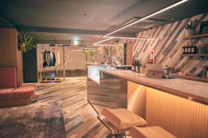 a kitchen with a bar with a laptop on the counter at Hotel She, Kyoto in Kyoto