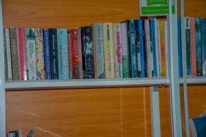 una fila de libros en una estantería de libros en Nice Place Beach Hotel, en Arugam Bay