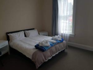 1 dormitorio con 1 cama con toallas en Gretna Hotel Taihape, en Taihape