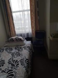 a bedroom with a bed with a pillow and a window at Gretna Hotel Taihape in Taihape