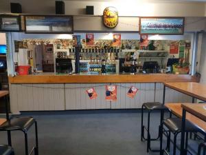 a restaurant with a bar with stools in front of it at Gretna Hotel Taihape in Taihape