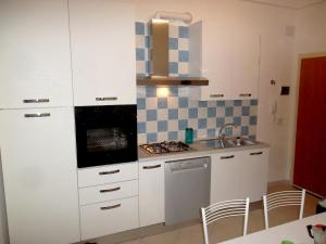 uma cozinha com armários brancos, um lavatório e um fogão em Grottammare mon amour Levante em Grottammare