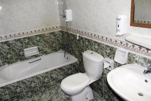 a white toilet sitting next to a sink in a bathroom at Sahara Hotel Apartments in Muscat