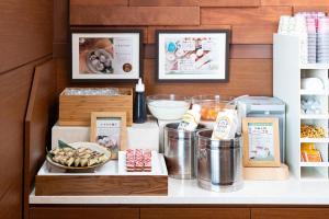a counter with food items on a shelf at Vessel Hotel Kumamoto Airport in Ozu