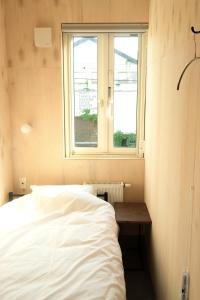 a bedroom with a white bed and a window at BEACH AND FIELD INN in Sapporo +31 photos