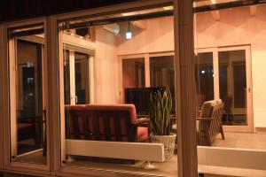 a room with sliding glass doors with a chair and a television at BEACH AND FIELD INN in Sapporo