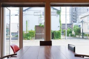 a conference room with a table and chairs and windows at BEACH AND FIELD INN in Sapporo
