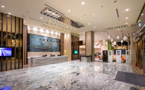 a lobby with a large marble floor and a television at Rice Resort Hotel in Taitung City