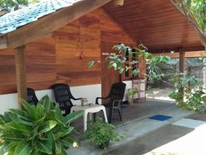 pérgola de madera con 2 sillas y mesa en Bella Nilaveli Beach, en Nilaveli