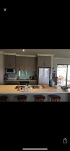 a kitchen with a counter with chairs in it at Relaxarna in Robe