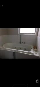 a white bath tub in a bathroom with a window at Relaxarna in Robe