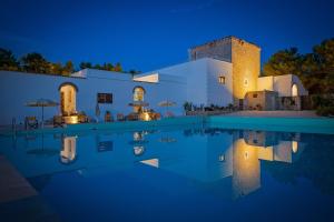 a villa with a swimming pool at night at torre casciani in Ugento
