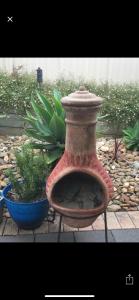 a vase sitting on a stand next to a plant at Relaxarna in Robe