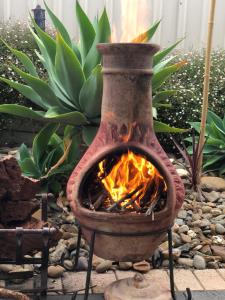 een stenen oven met een open haard in de tuin bij Relaxarna in Robe