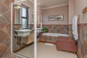a bathroom with a tub and a sink and a shower at Whale Away Guest House in Hermanus