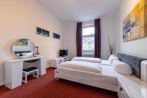ein Hotelzimmer mit 2 Betten und einem Spiegel in der Unterkunft Trip Inn Hotel Schumann in Düsseldorf