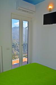 a bedroom with a large window with a view of the mountains at Palazzo Mansi in Ravello
