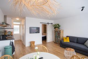 una sala de estar con un sofá y una mesa en Appartement Zuyd, en Zandvoort