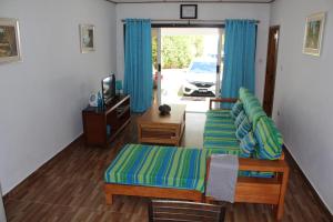 a living room with blue curtains and a couch at Farida Apartments in Pointe Au Sel 