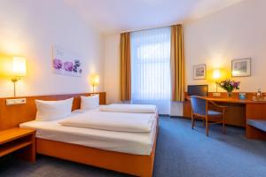 a hotel room with two beds and a desk at Trip Inn Hotel Schumann in Düsseldorf +46 photos