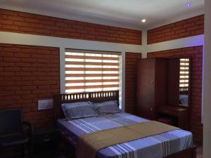 ein Schlafzimmer mit einem Bett in einer Ziegelwand in der Unterkunft Marsim Holiday Resort in Vythiri