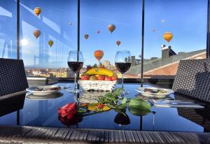 a table with wine glasses and a basket of fruit and balloons at EL NAZAR STONE SUİTE in Uçhisar