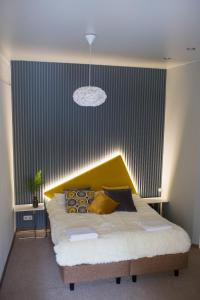 a bedroom with a large bed with a yellow headboard at Loft on Sadovaya in Saint Petersburg