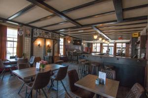 a restaurant with tables and chairs and a bar at Hart van Bourdonck in Boerdonk