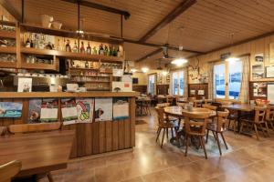 ポスキアーヴォにあるリストランテ ペンシオーネ シャレー スタツィオーネのテーブルと椅子が備わるウッドフロアのレストランを併設しています。