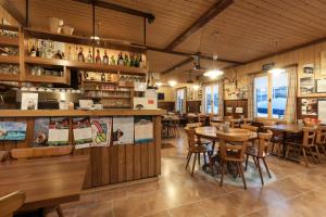 ein Restaurant mit Holzböden, Tischen und Stühlen in der Unterkunft Ristorante Pensione Chalet Stazione in Poschiavo