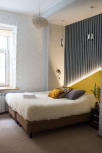 a bedroom with a large bed with a yellow headboard at Loft on Sadovaya in Saint Petersburg