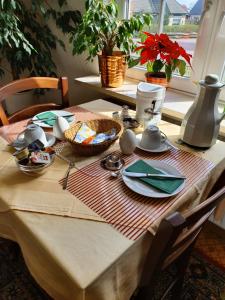 een tafel met een tafelkleed op een tafel met borden en borden bij Haus-Eilers-Borkum in Borkum