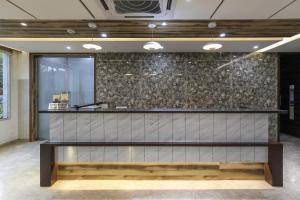 a bar in a lobby with a stone wall at Hotel Ashray Inn Express in Ahmedabad