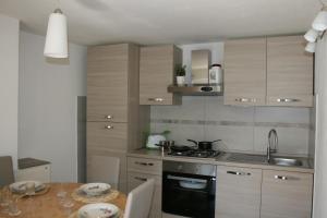 una cocina con armarios de madera y una mesa con fregadero en Ca' Rossi, en Beverino