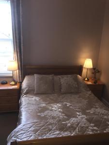 a bedroom with a bed with two lamps and a window at Chiverton House Guest Accommodation in Penzance