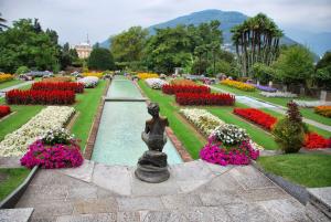 a garden with flowers and a statue in the middle at Casa Azalea in Verbania