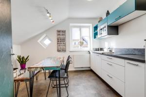 a kitchen with white cabinets and a table with chairs at Gerli Appartement Mariazell in Mariazell