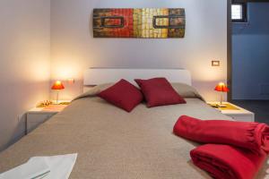 ein Schlafzimmer mit einem großen Bett mit roten Kissen in der Unterkunft B&B Eco in Pompei