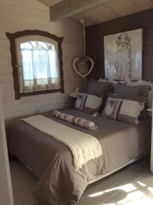 two beds in a bedroom with a mirror and a window at Chalet de Charme in Aniane