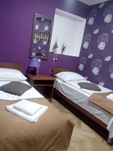 two beds in a room with purple walls at Tbilisi Downtown Guest House in Tbilisi City