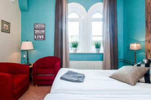 a bedroom with a bed and a chair and a window at Centralstationens Vandrarhem in Norrköping