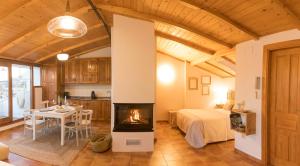 a living room with a fireplace and a bedroom at La Buhardilla de Huecar in Cuenca