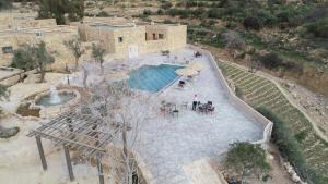 an overhead view of a pool with tables and umbrellas at The Old Village Hotel & Resort in Wadi Musa