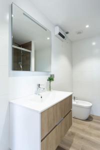 uma casa de banho com um lavatório, um espelho e uma banheira em Indigo Rooftop em La Coruña