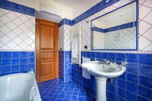 a blue tiled bathroom with a sink and a mirror at Casale Ceppone in Vico Equense +40 photos