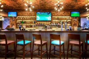 a bar with four chairs and a counter with alcohol at Citymax Hotel Bur Dubai in Dubai