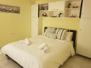 a white bed with two rolled towels on it at COZZY STUDIO IN NEA MAKRI in Nea Makri