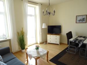- un salon avec un canapé et une table dans l'établissement Fürstenhof Fewo Beagle, à Sassnitz