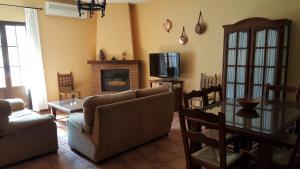 a living room with a couch and a table and a tv at Casitas Cueva del Gato in Benaoján